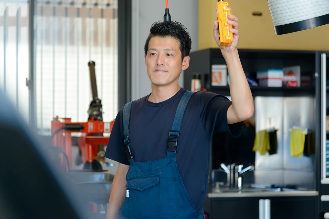 売り場の前で両手を前にして微笑む男性の写真